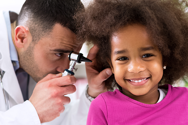 Doctor examining a young patient's ear