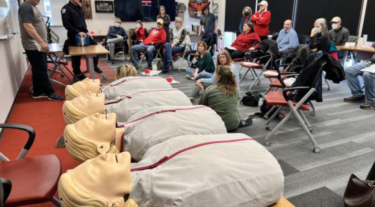 Four CPR manikins lined up on a table