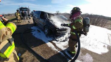 Firefighters extinguishing vehicle fire