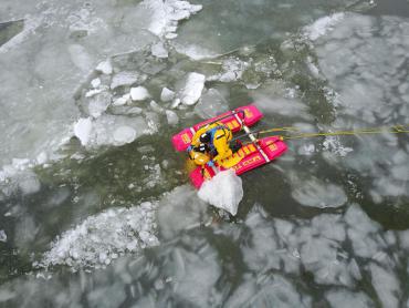 Overhead view of rescuer securing somebody to the sled