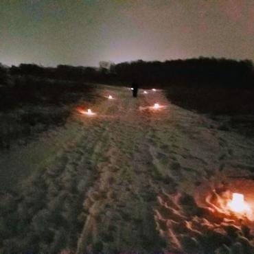 snow covered trail with candlelights