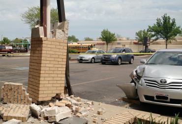 Vehicle hits building. Causing damage to brick post.