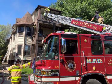 Firefighter climbs aerial ladder to top floor of apartment building