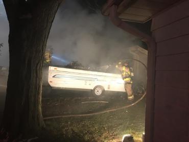 Firefighters extinguishing pop-up camper