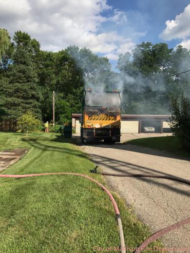 Garbage truck with smoke coming out of the back