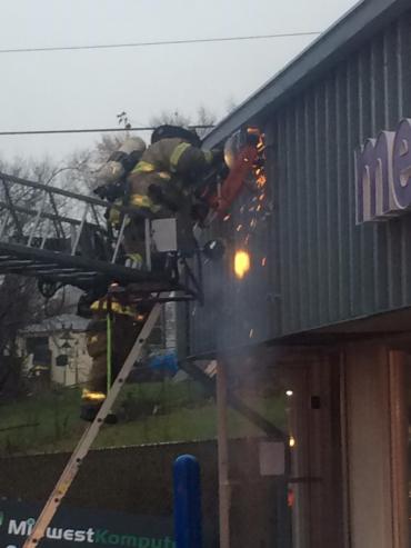 Firefighters cutting away at soffit