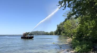 Lake Rescue Team sprays water onto tree from boat turret