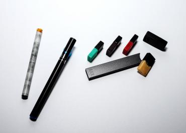 Three e-cigarettes and filters laying on a table