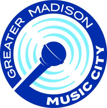 A microphone in dark blue is pictured in the center of radiating light blue pulsing semi circles. An outer band of dark blue has the text Greater Madison Music City in white. 