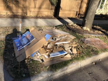 Stack of loose cardboard at the curb that is not bound, which means it may be very difficult for someone to collect