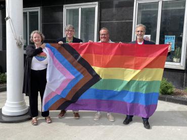 Mayor Satya holding the Intersectional  Pride flag  before raising it at the City County Building