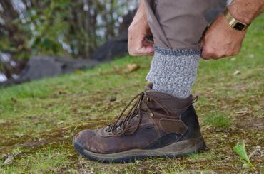 A person tucking their pants into their socks outdoors