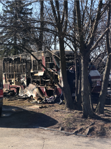 Burned motor home parked next to trees