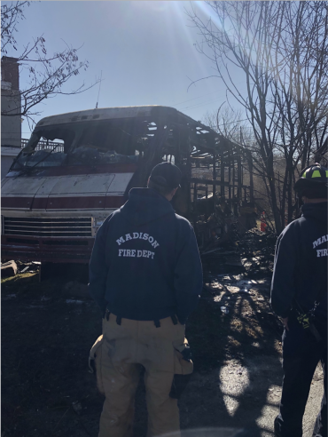 Fire investigators look at the damaged motor home