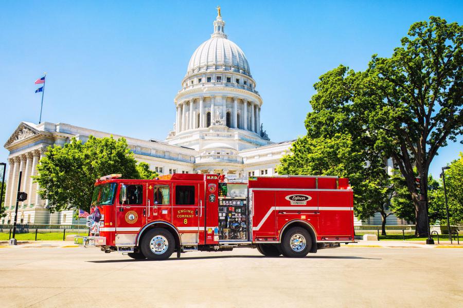 Electric fire truck parked in front of the Wisconsin State Capitol building.