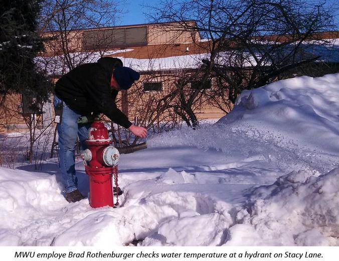 Hydrant inspector takes temperature of water running from a hydrant