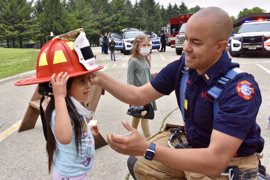 Lt. Kevin McDonald helps student try on his helmet