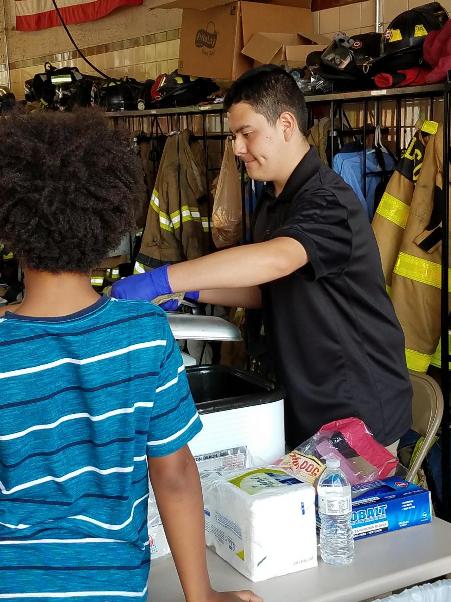 Abe Ruiz serves food at Firefighter Fun Day
