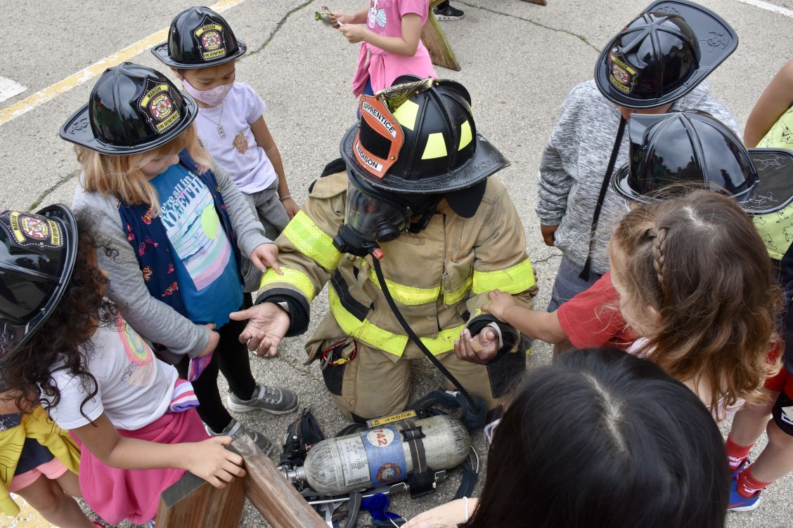 Students touch firefighter/paramedic Tasha Kirch's gear