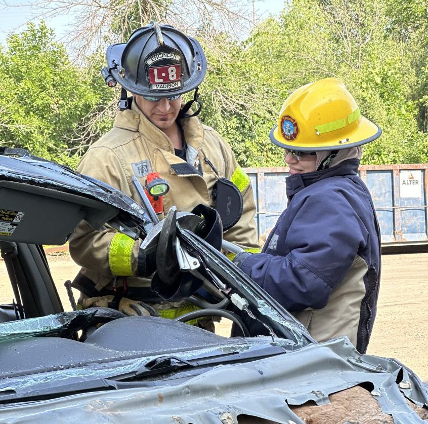 A firefighter assists a medical resident with the Jaws of Life