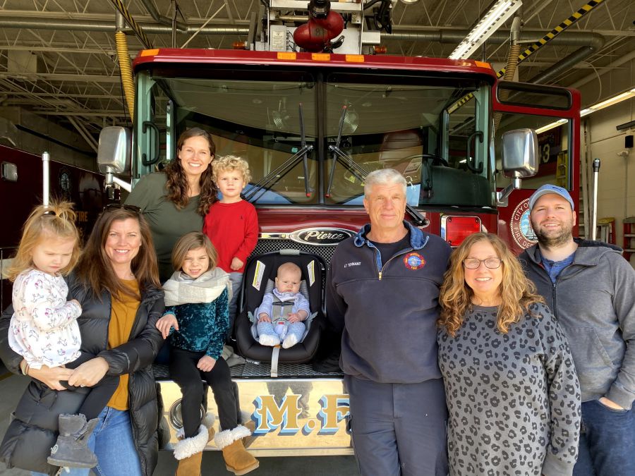 Lt. Steve Tennant with family by ladder truck