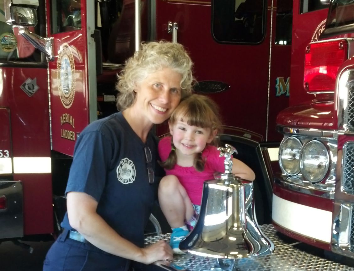 Jen Román with granddaughter Abuela by fire truck