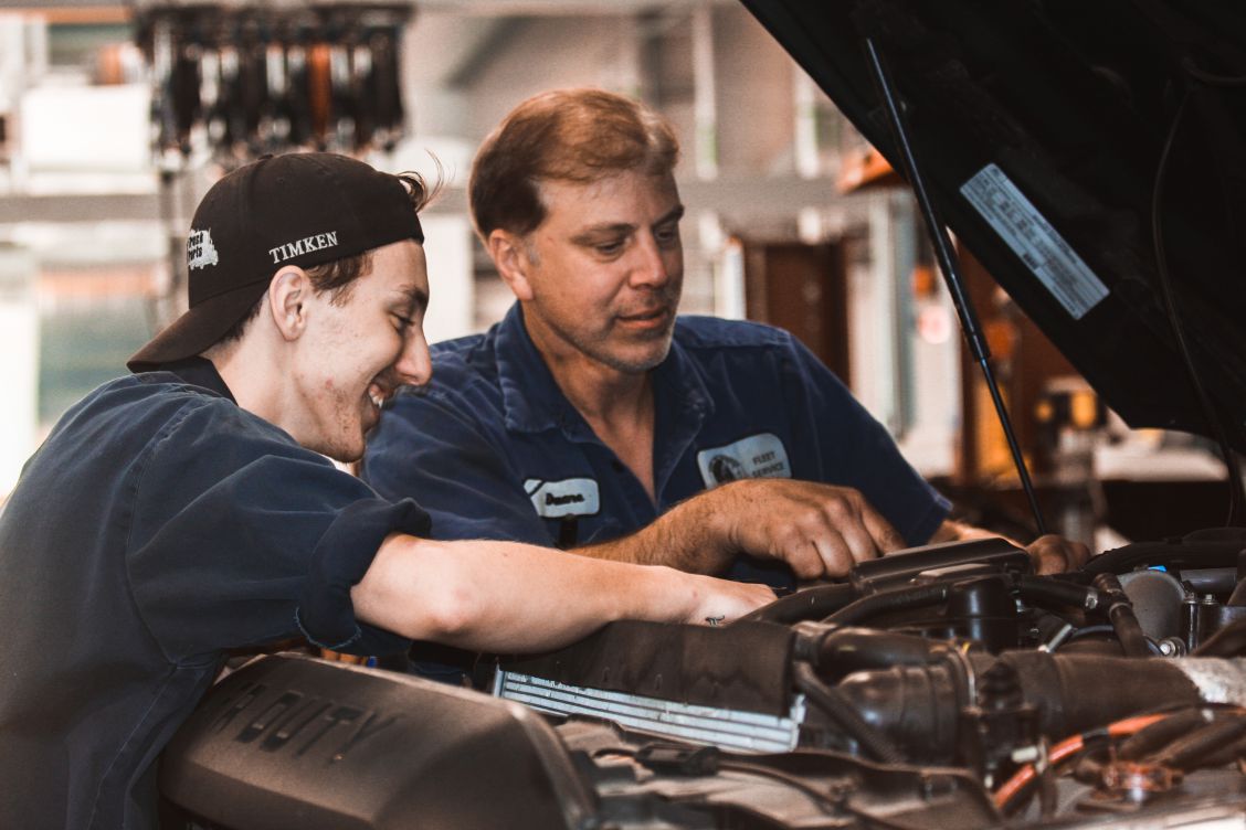 Luc with his mentor working under the hood of a truck