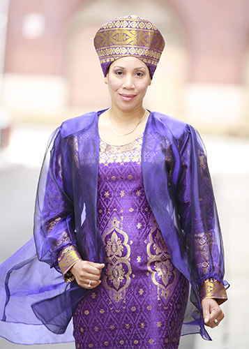 Quanda Johnson, a person with medium brown skin, wearing a purple and gold head covering.