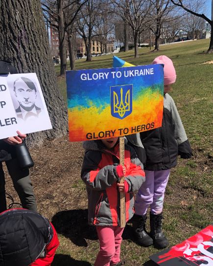 child with sign at Ukraine demonstration