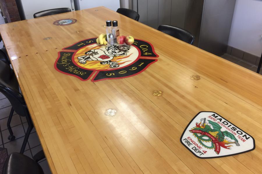 Custom Tabletop - This custom table top displays the Station 4 “Bucky’s House” logo, the MFD logo, and the patch for the Rapid Intervention Team, formerly based at Station 4.