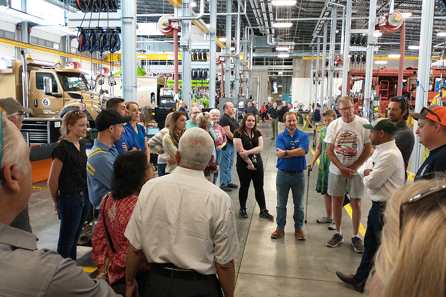 A large group inside the Fleet heavy duty repair garage during a tour of the new building