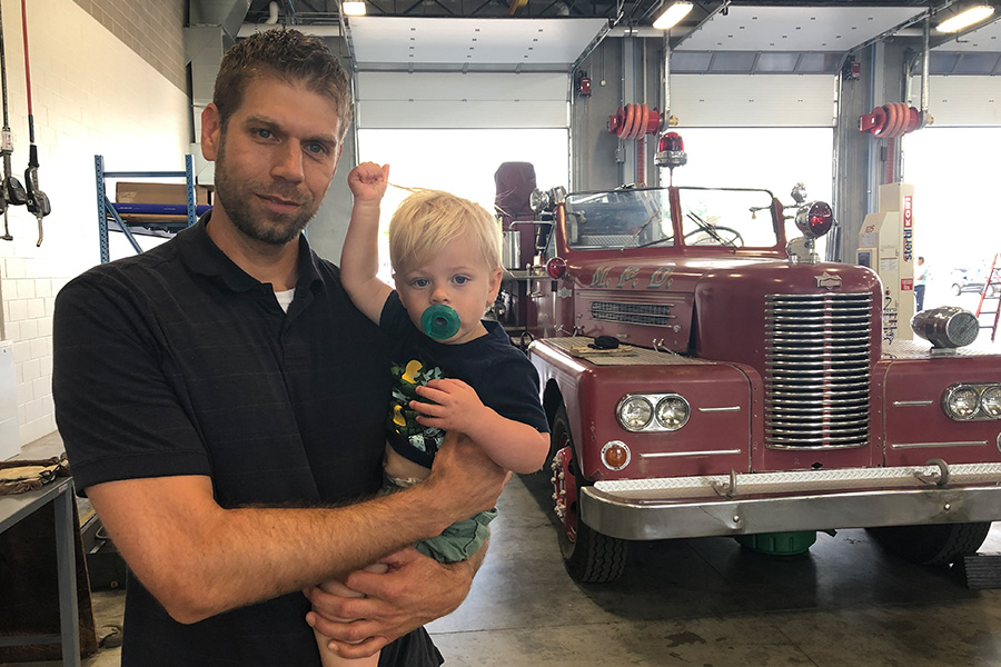 A father and son pose with the 1959 Pirsch Fire Ladder