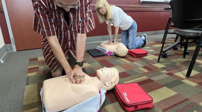 Participants practice hands-only CPR on a mannikin