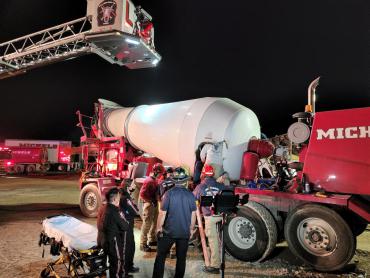 EMS and rescue crews work to rescue man from inside a cement mixer