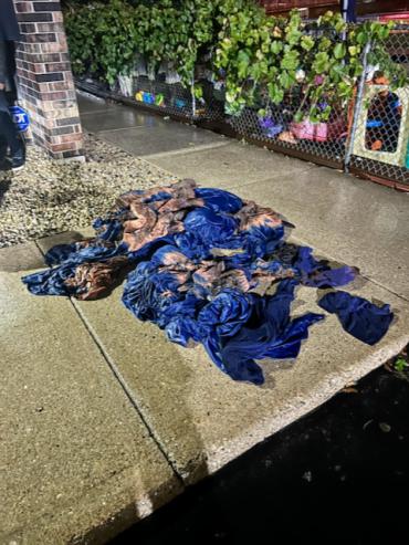 a pile of blue sheets damaged by fire, wet from being extinguished by firefighters