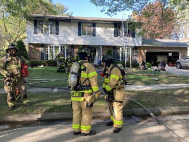 Firefighters standing in front of house