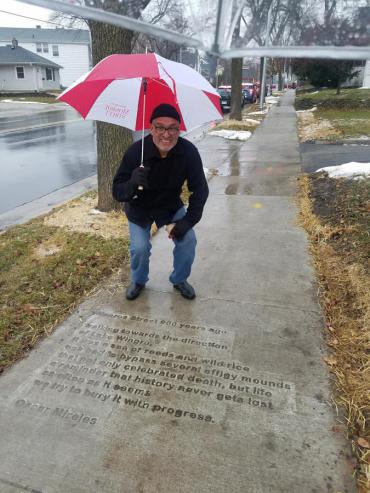 Oscar Mireles by his sidewalk poem near Wingra Park entrance on Monroe Street.