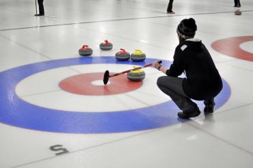person curling on the ice holding a broom