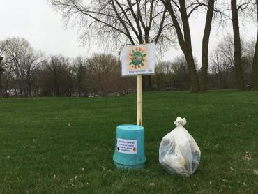 earth day challenge sign, bucket and filled trash bag