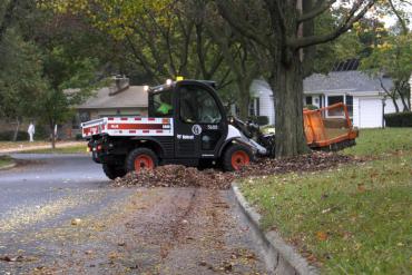 Leaf collection vehicle pulling yard waste from the terrace. Pickup begins April 6. Expect delays.
