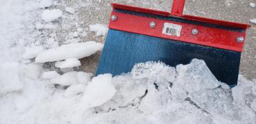 A photo of a salt pavement scraper that helps with manual removal of snow and ice.