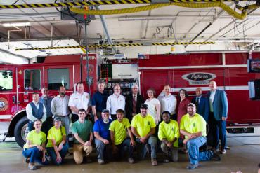 City staff, vendors, governor, mayor pose for a group photo to celebrate new electric milestone
