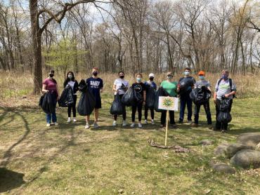 Madison mayor, and volunteers standing in a park with trash bags
