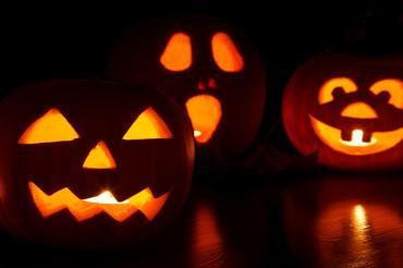 Three carved Halloween pumpkins at night