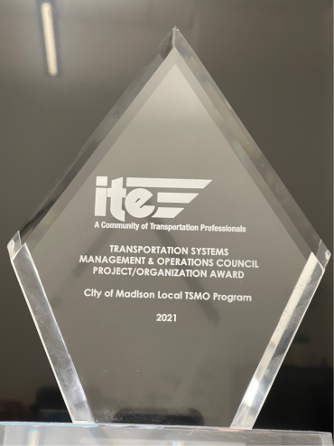 Image of the transparent, glass, diamond shaped, 2021 Transportation Systems Management & Operations Council Organization Award award written in white lettering