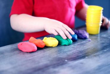 A child plays with colored clay at a childcare center