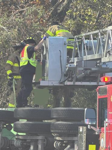 Firefighters assist driver into the basket of Ladder 8