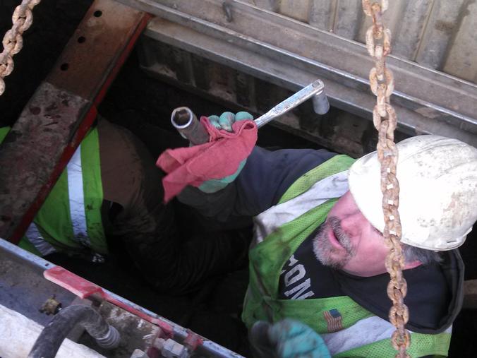 Worker inside the hole hands off tool