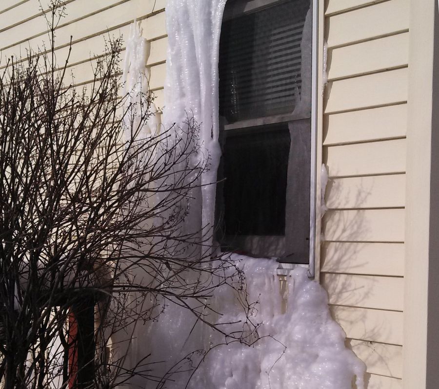 Ice dam forms where water has been seeping out of window